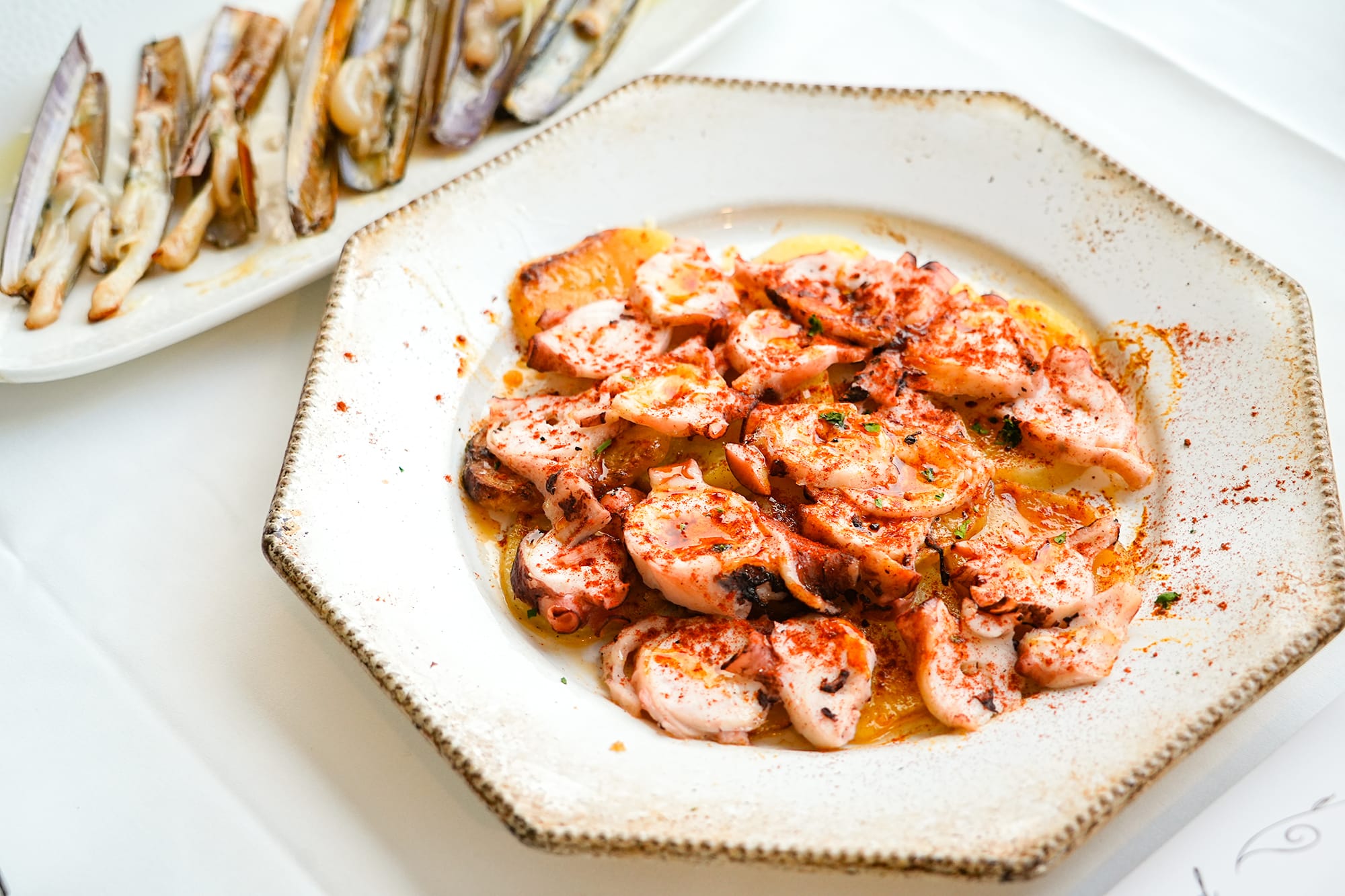 Plato de pulpo fresco emplatado con estilo mediterráneo en El Portinyol, restaurante del Maresme con fotografía profesional para redes