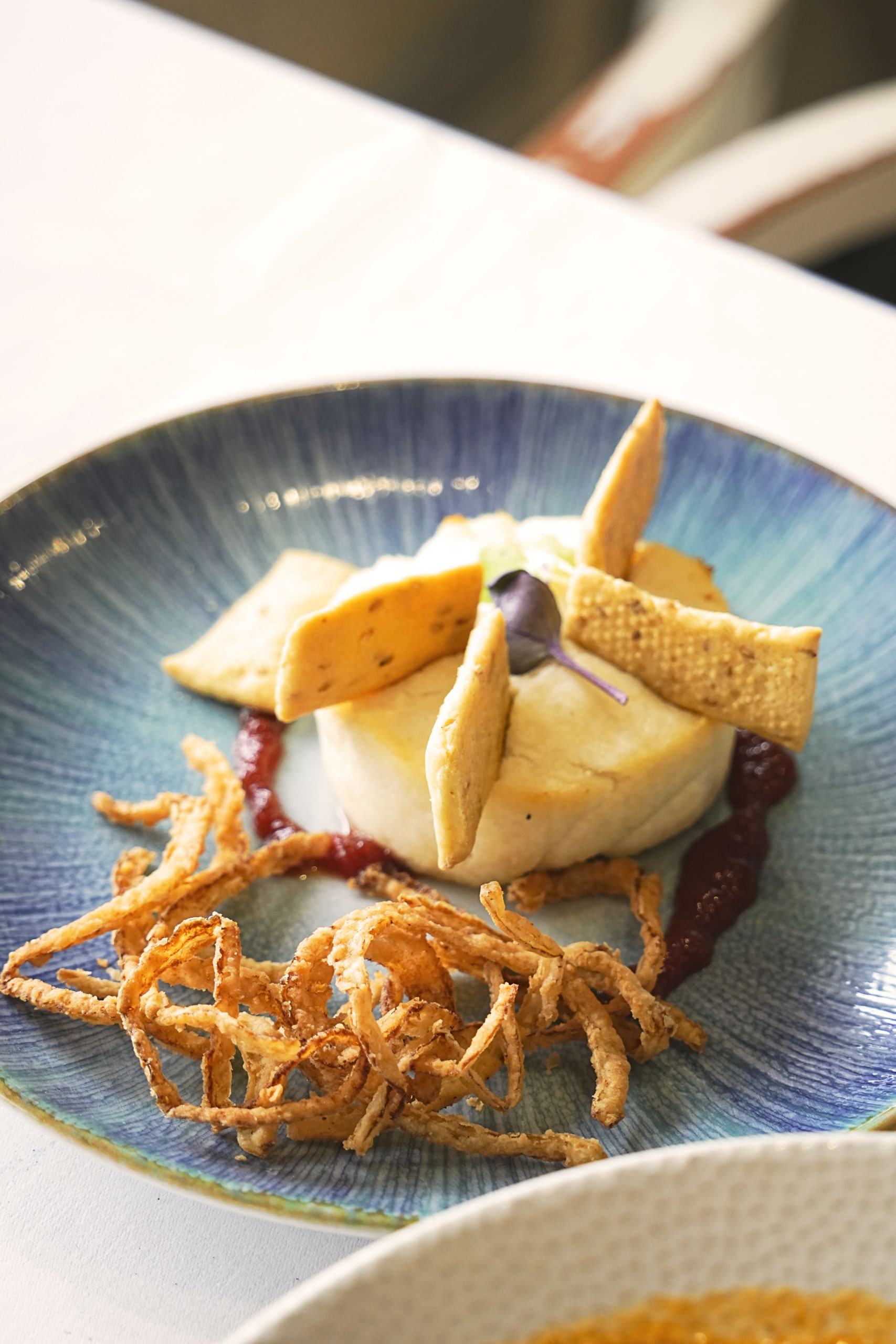 Plato de pescado fresco emplatado con estilo mediterráneo en El Portinyol, restaurante del Maresme con fotografía profesional para redes