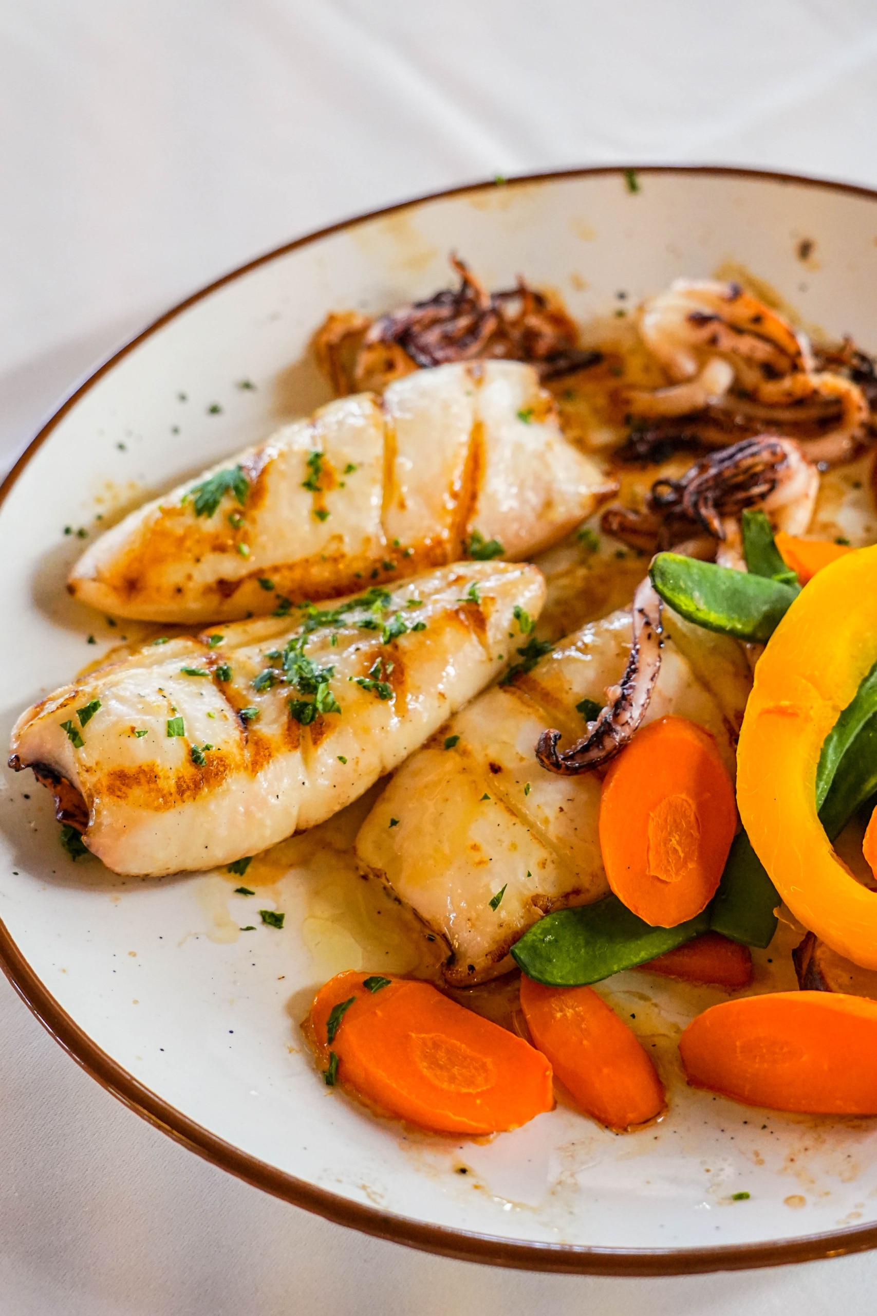 Plato de pescado fresco emplatado con estilo mediterráneo en El Portinyol, restaurante del Maresme con fotografía profesional para redes