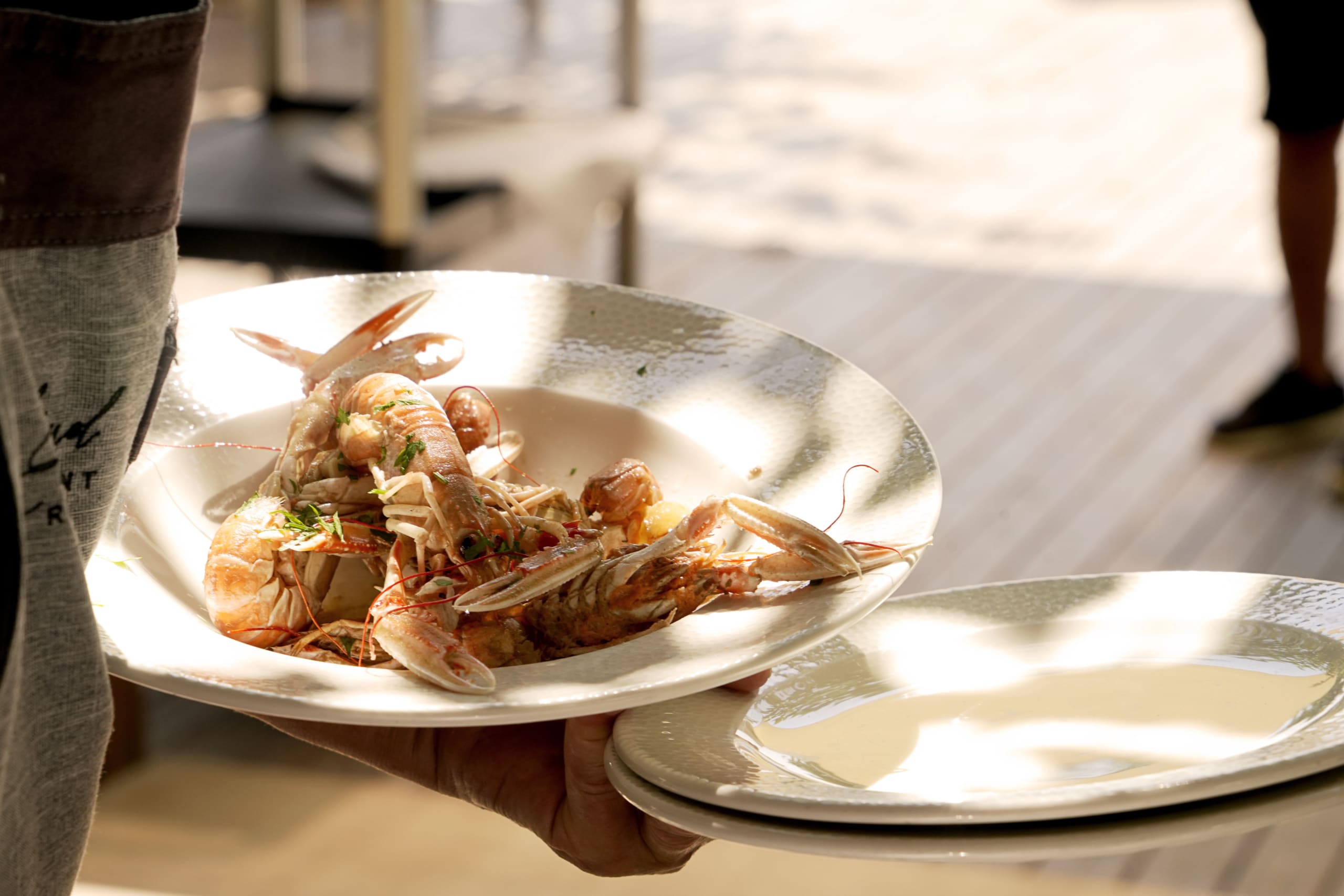 Plato de pescado fresco emplatado con estilo mediterráneo en El Portinyol, restaurante del Maresme con fotografía profesional para redes