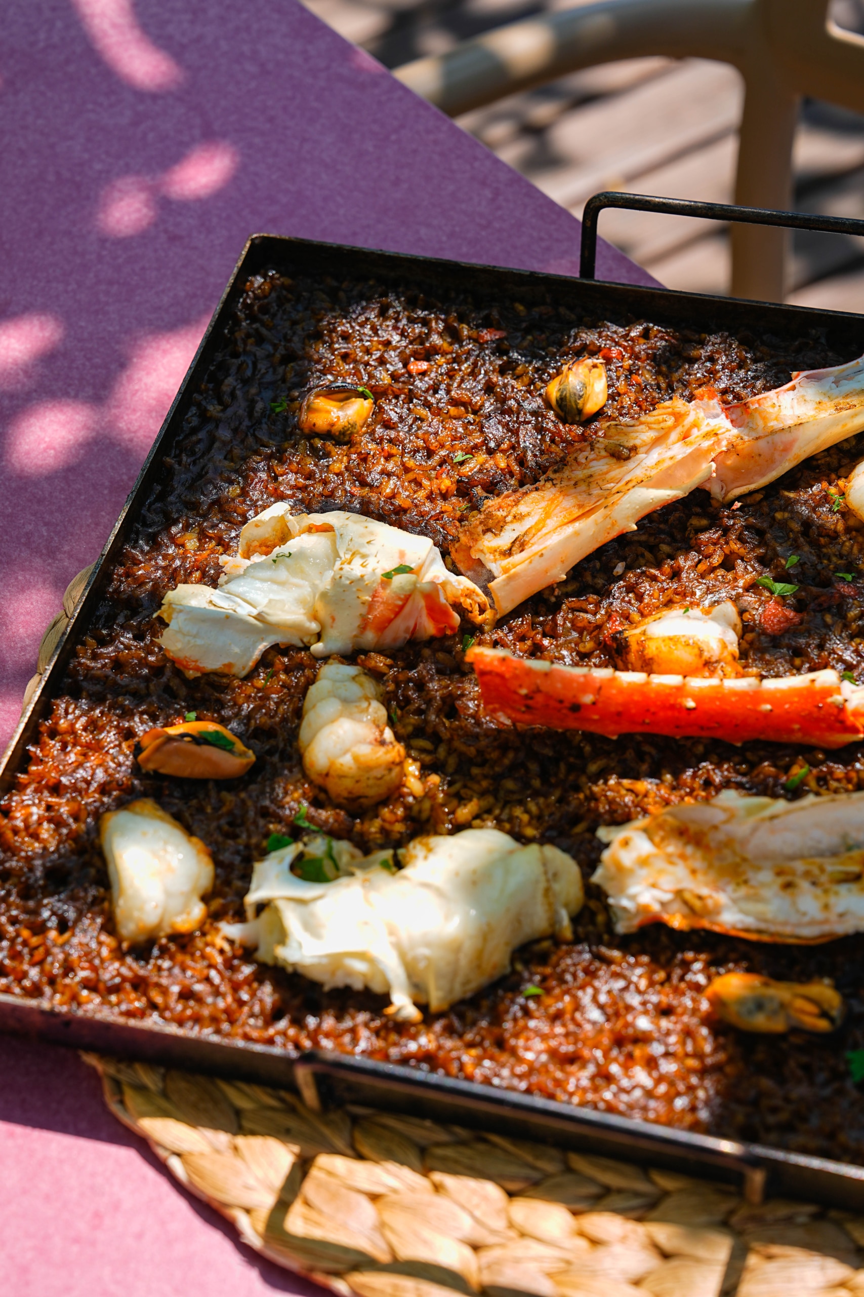 Detalle de arroz del senyoret en mesa de terraza frente al mar en El Portinyol, ideal para contenido visual de Instagram
